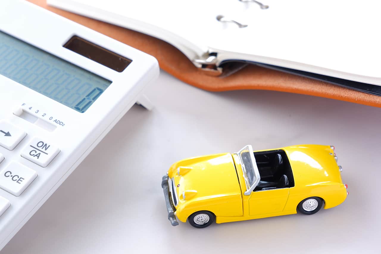 電卓と黄色いミニカーと手帳